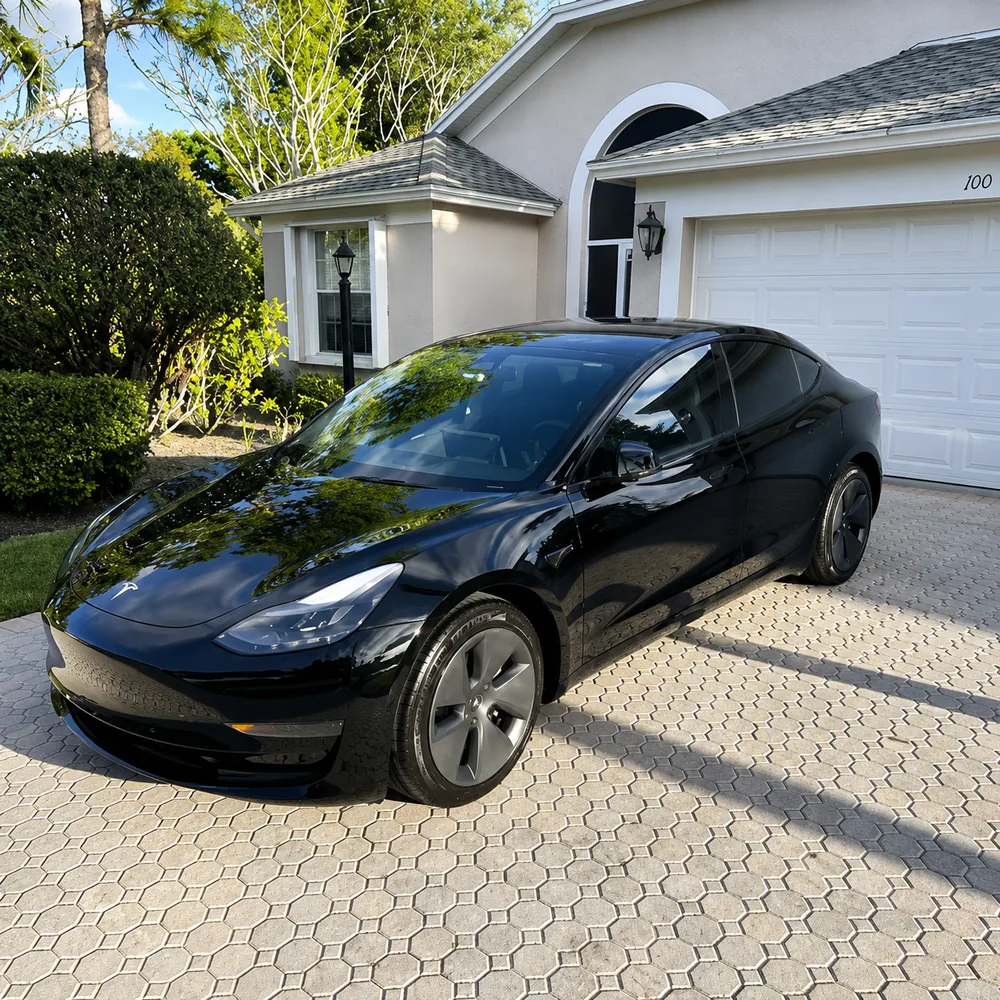 Freshly detailed black sedan parked in a driveway
